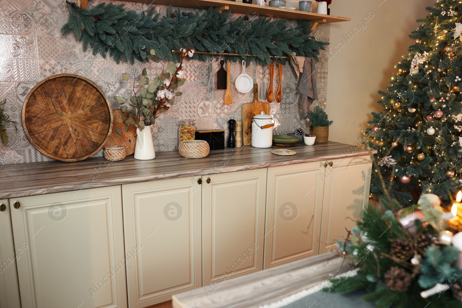 Photo of Stylish kitchen with festive decor and Christmas tree. Interior design