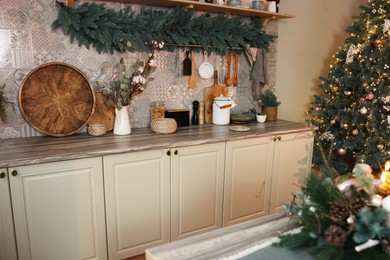 Stylish kitchen with festive decor and Christmas tree. Interior design