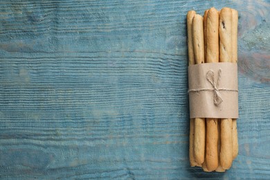 Delicious grissini sticks on wooden table, top view. Space for text