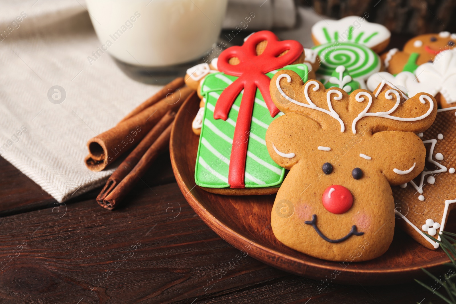 Photo of Plate with tasty Christmas cookies on wooden table, closeup