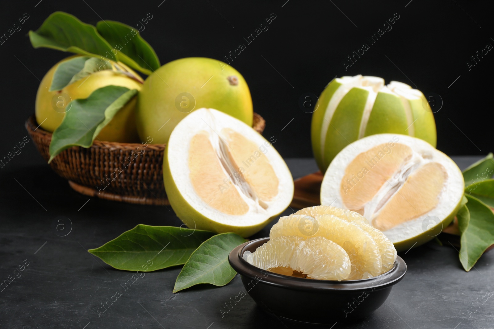 Photo of Fresh cut pomelo on black table, closeup