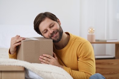Photo of Happy man with parcel at home. Internet shopping