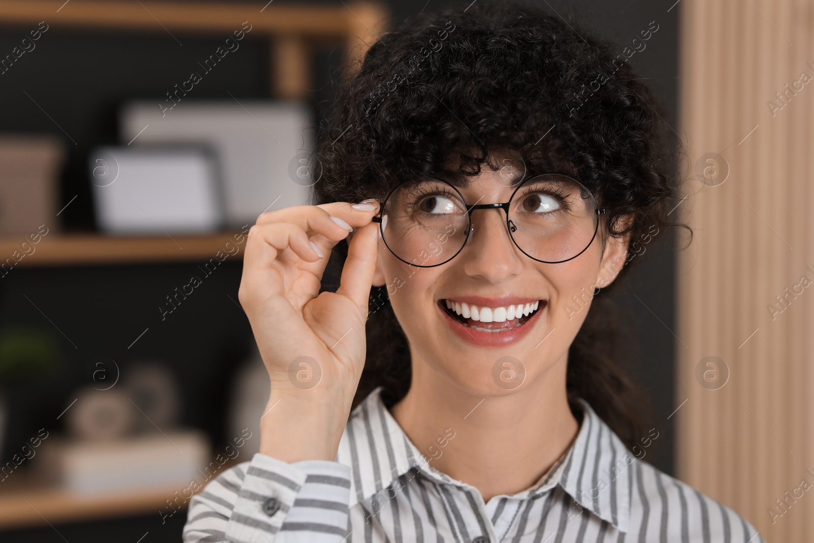 Photo of Portrait of beautiful woman in glasses indoors. Attractive lady smiling and posing for camera