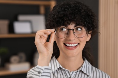 Portrait of beautiful woman in glasses indoors. Attractive lady smiling and posing for camera