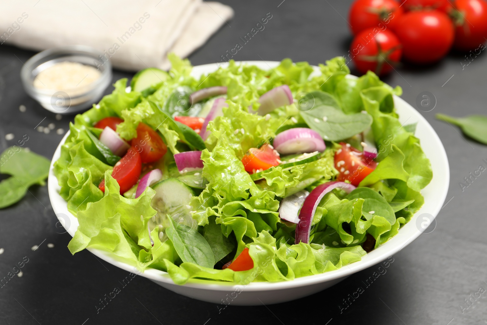 Photo of Delicious salad in bowl on grey table, closeup