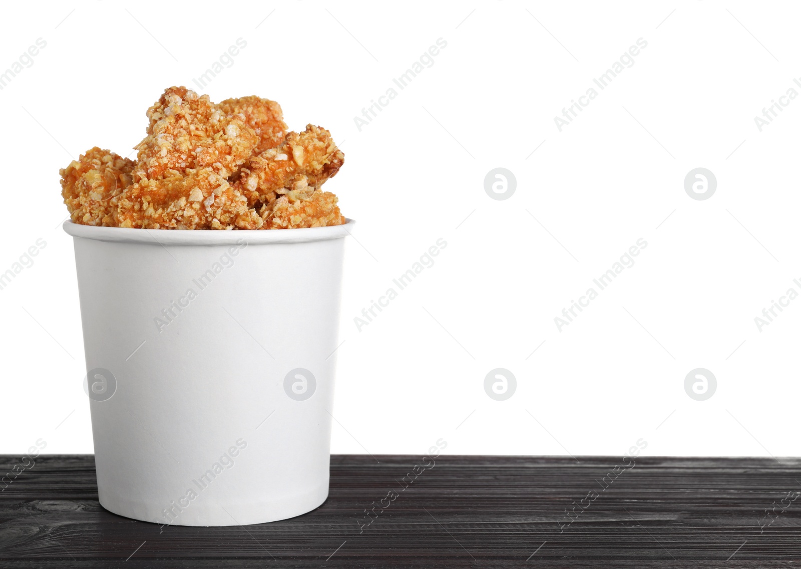 Photo of Bucket with yummy nuggets on wooden table against white background, space for text