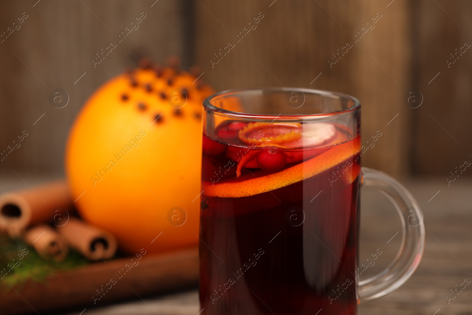 Photo of Aromatic mulled wine in glass cup on table, closeup. Space for text