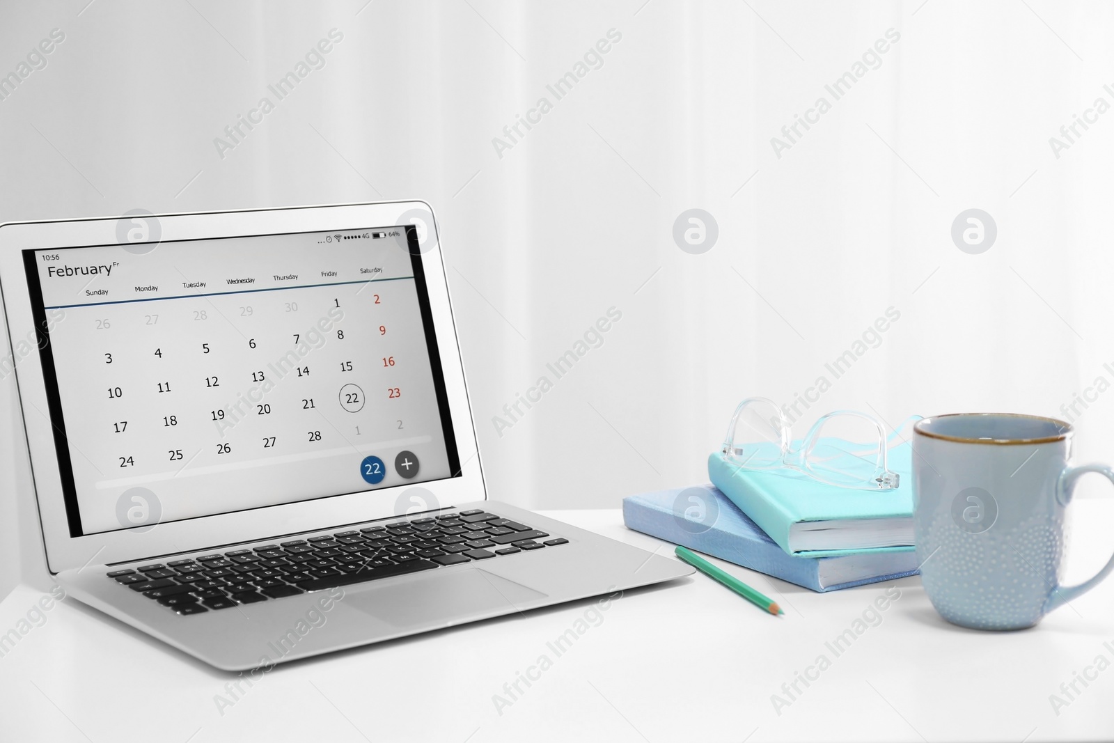 Photo of Modern laptop with calendar on screen in office