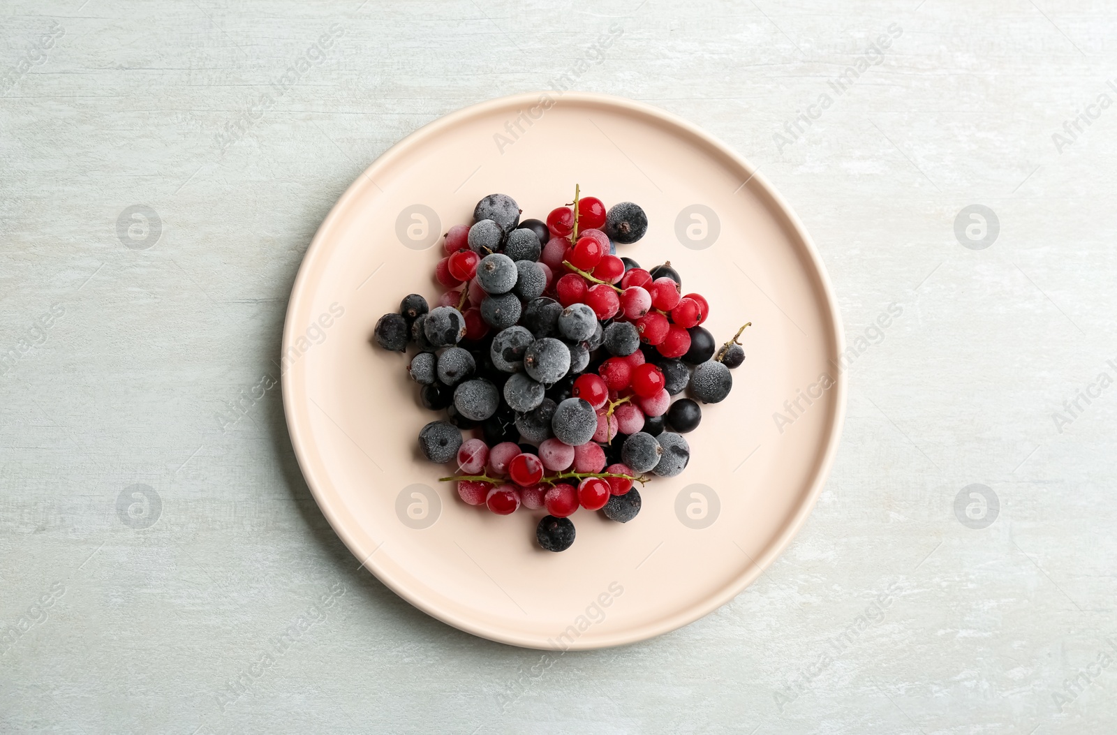 Photo of Tasty frozen red and black currants on white table, top view