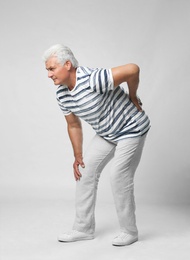 Photo of Full length portrait of senior man having knee problems on grey background