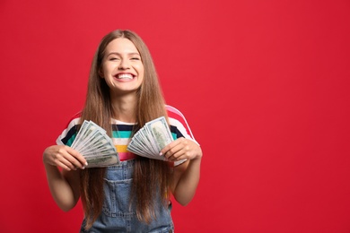 Portrait of happy lottery winner with money on red background, space for text