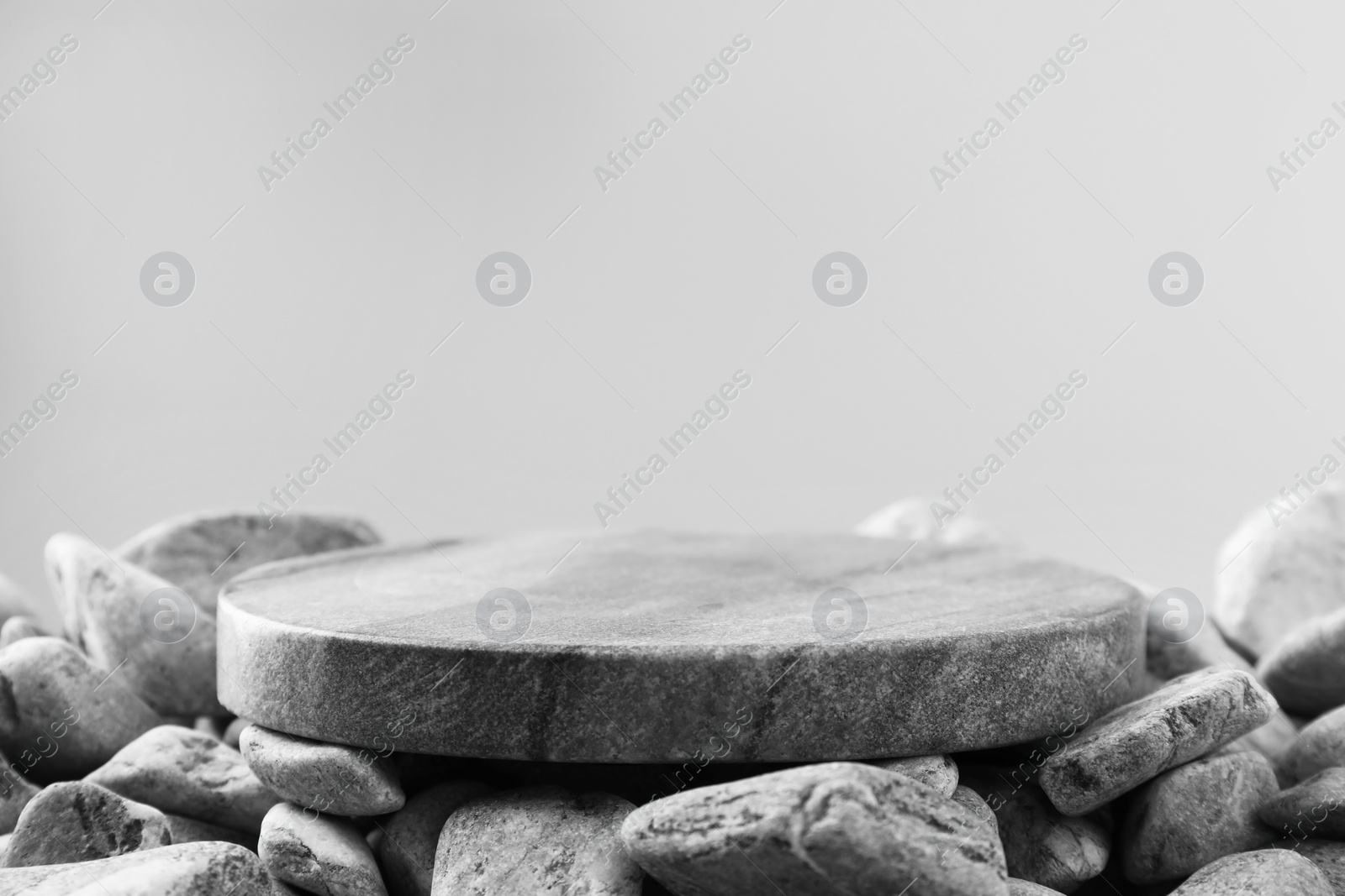 Photo of Presentation for product. Stone and pebbles on grey background. Space for text