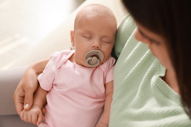 Photo of Mother holding her cute sleeping baby at home, above view