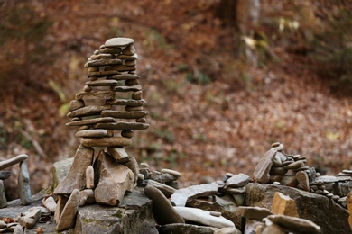 Photo of Tower of balancing stones in forest. Space for text