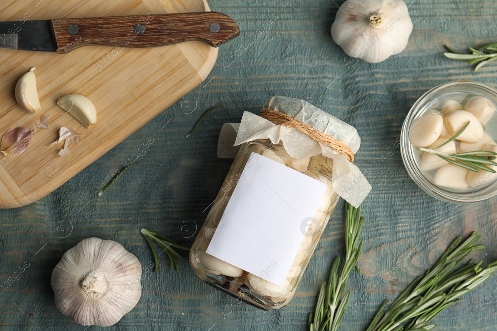 Photo of Flat lay composition with jar of pickled garlic on blue wooden table