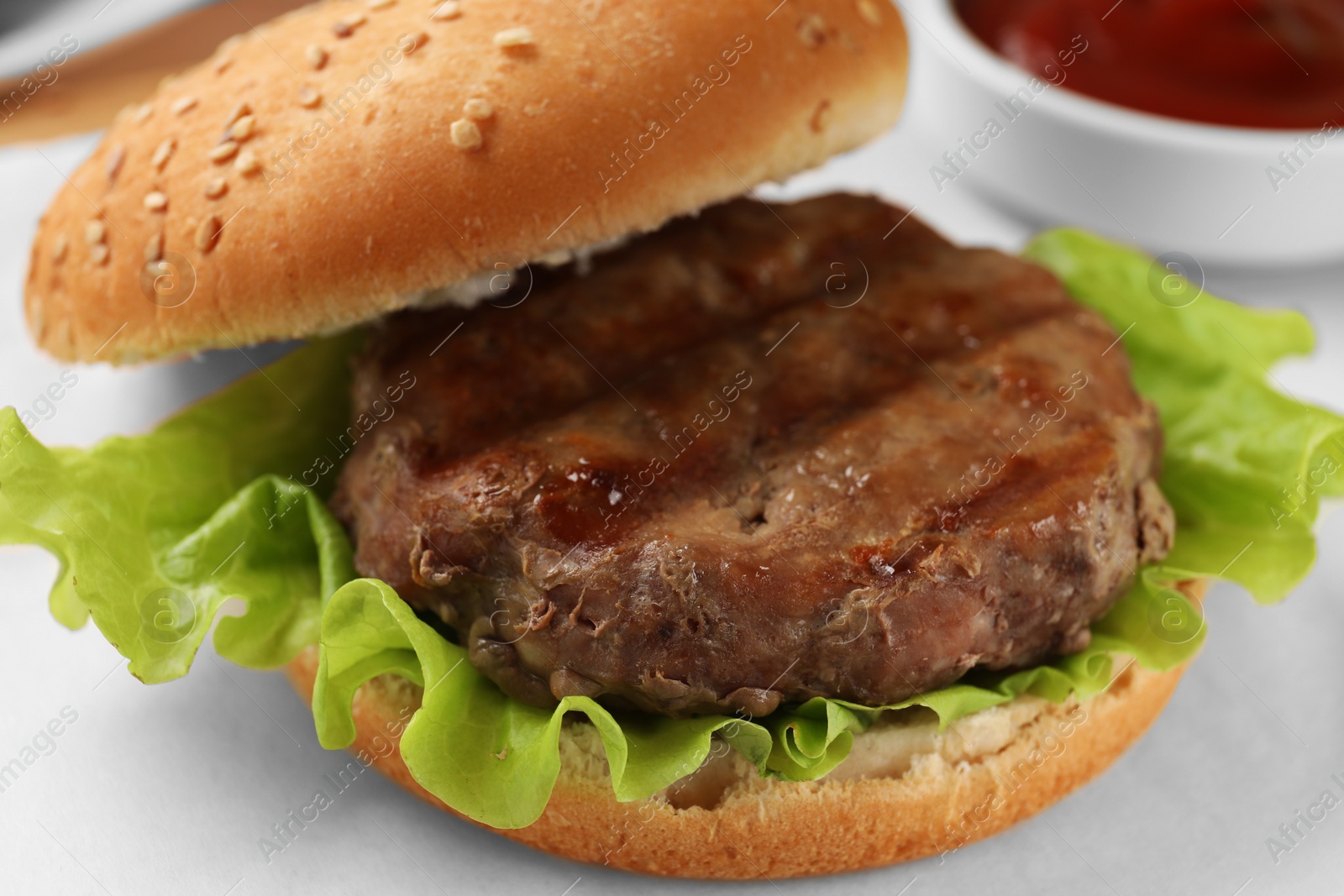 Photo of Delicious fried patty, lettuce and buns on white table, closeup. Making hamburger