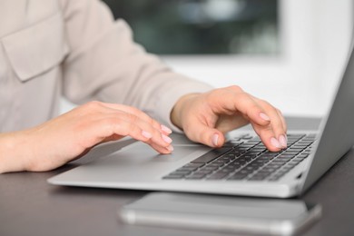 Woman working on laptop at table, closeup. Electronic document management