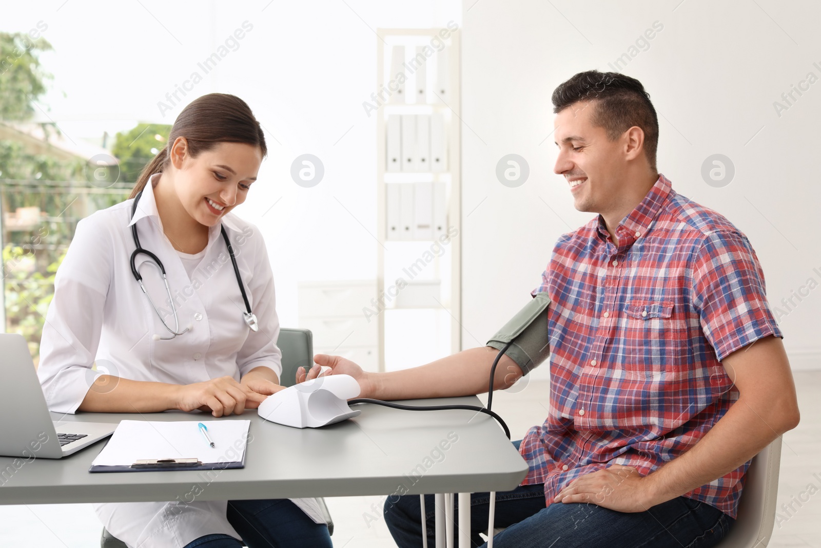 Photo of Doctor checking patient's blood pressure in hospital