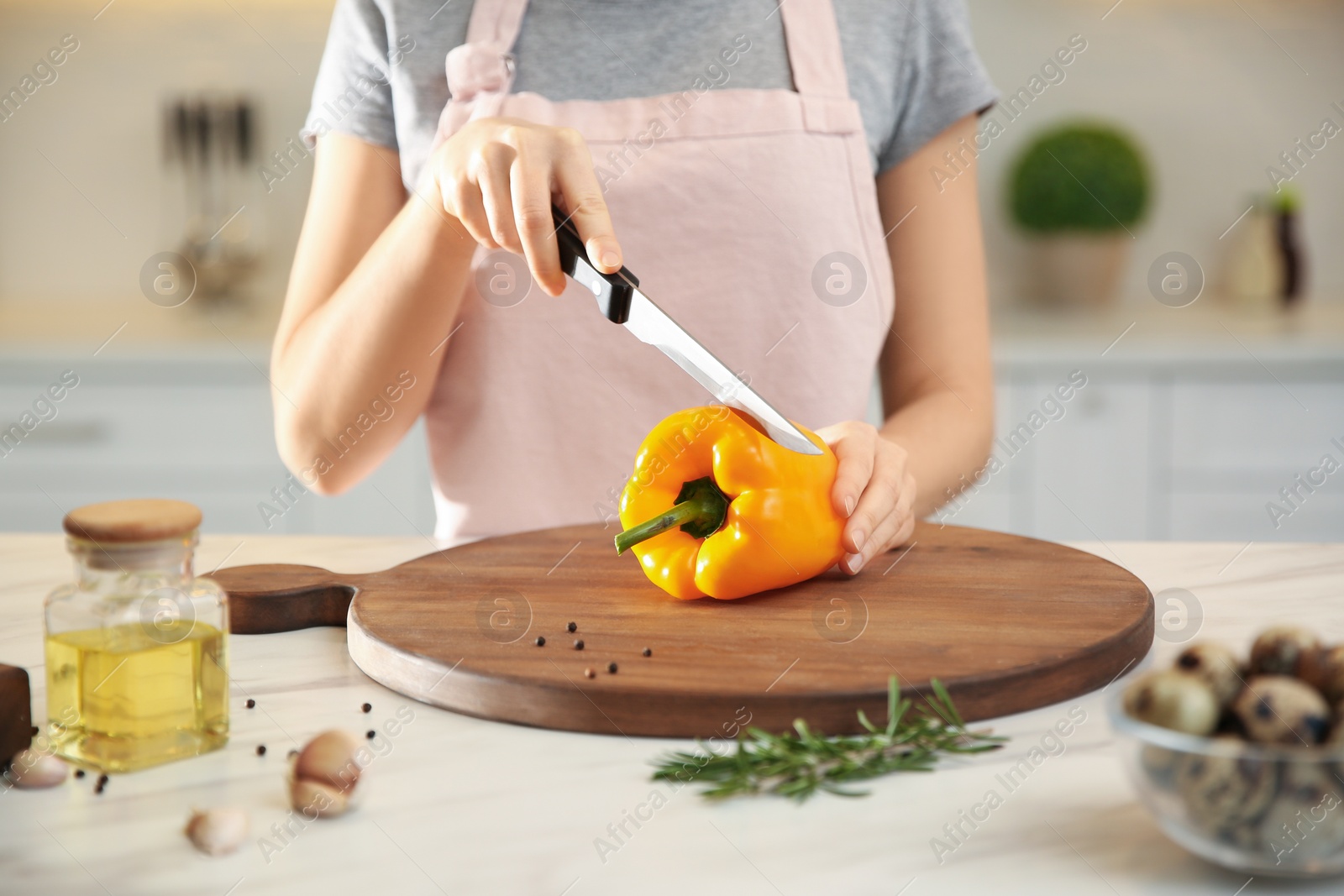 Photo of Young woman cooking at table in kitchen, closeup