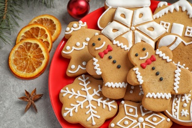 Photo of Plate with tasty homemade Christmas cookies on grey table, closeup