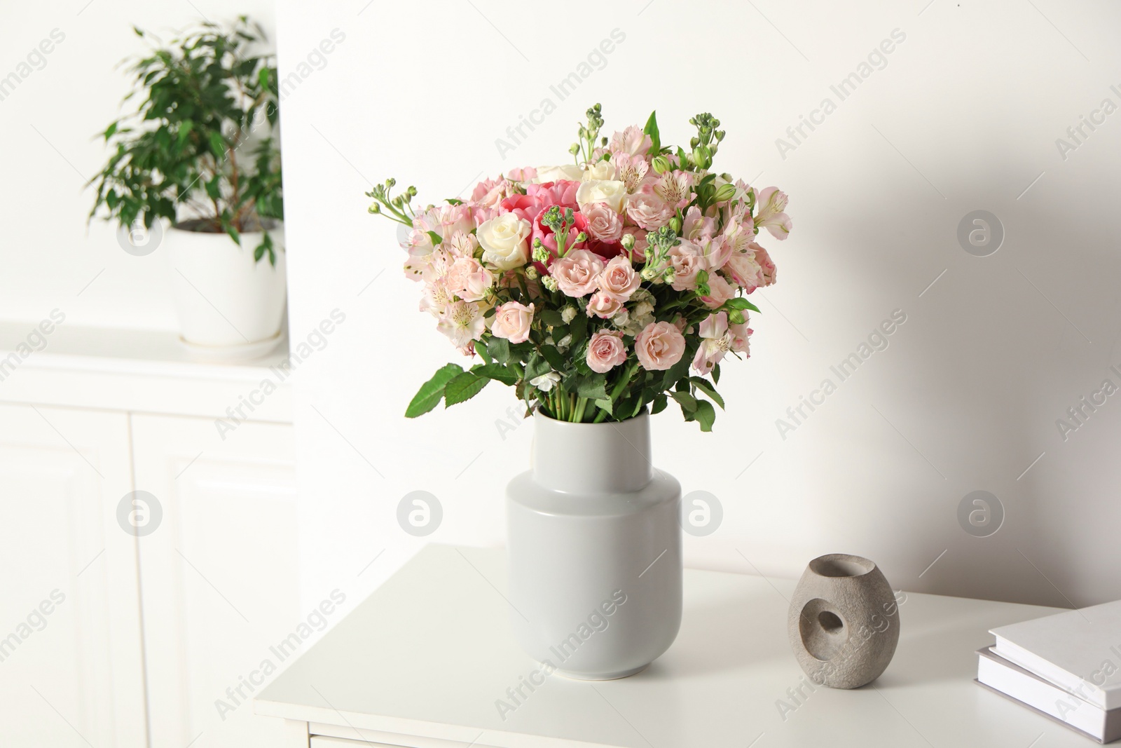 Photo of Beautiful bouquet of fresh flowers in vase on white table indoors