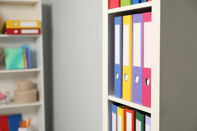 Photo of Colorful binder office folders on shelving unit indoors
