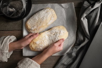 Photo of Woman cooking ciabatta at wooden table, top view