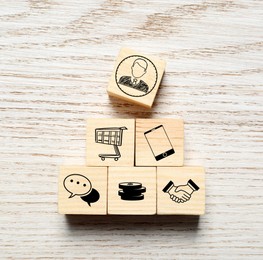 Professional buyer. Cubes with different icons on wooden table, top view