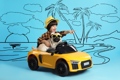 Cute little boy with his dog in toy car and drawing of tropical resort on light blue background