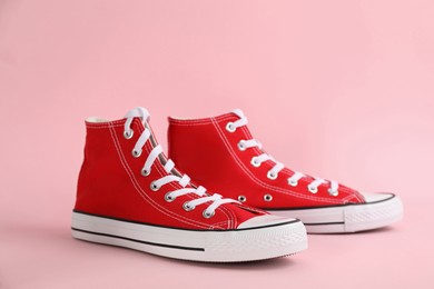 Photo of Pair of stylish sneakers on pink background