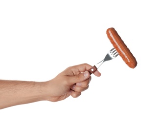 Photo of Man holding fork with grilled sausage on white background, closeup. Barbecue food