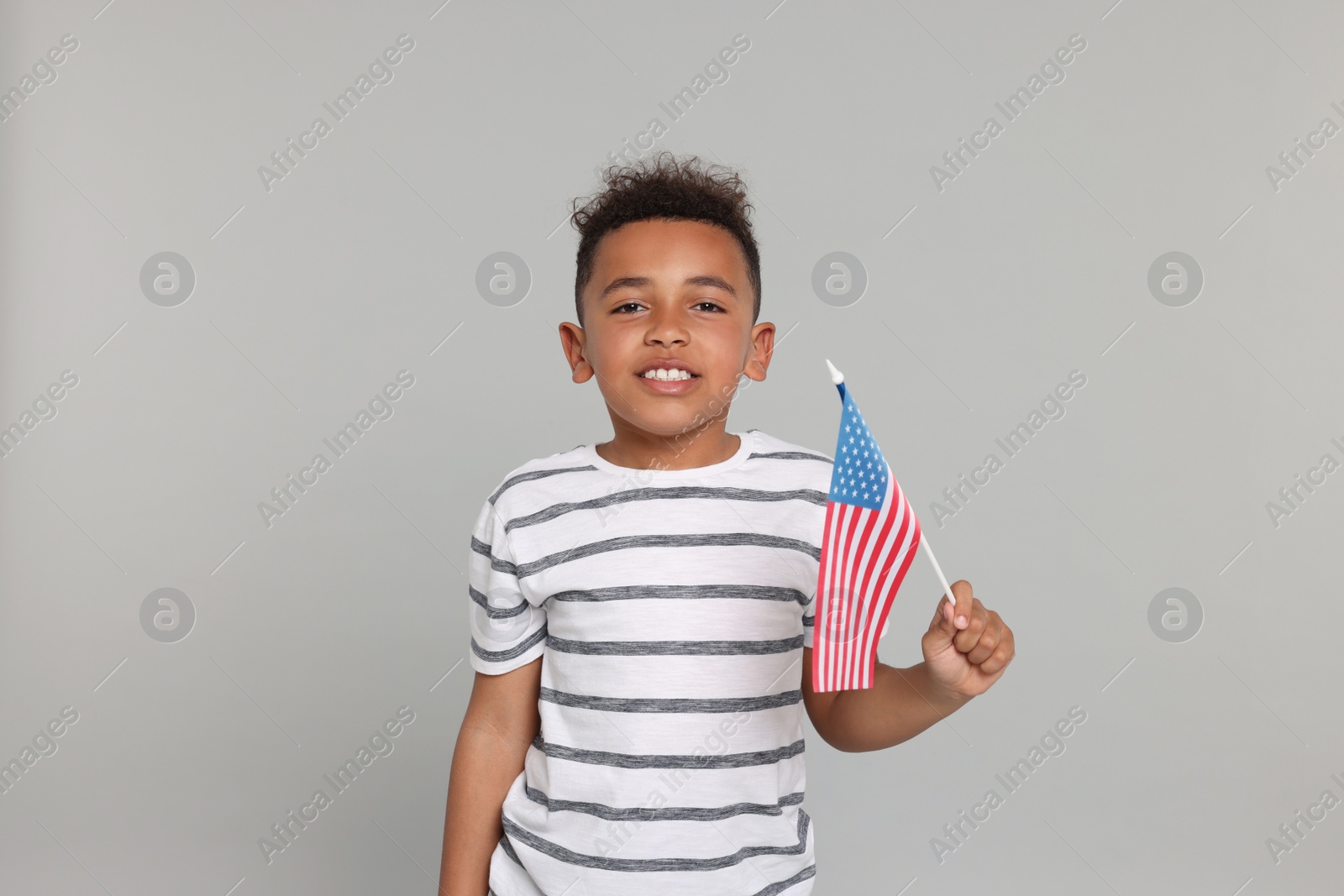 Photo of 4th of July - Independence Day of USA. Happy boy with American flag on light grey background