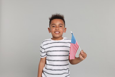 Photo of 4th of July - Independence Day of USA. Happy boy with American flag on light grey background