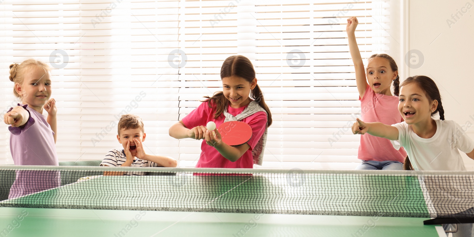 Image of Cute happy children playing ping pong indoors. Banner design