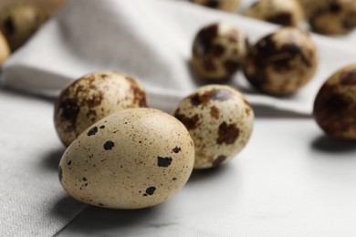 Photo of Many speckled quail eggs on white table. Space for text