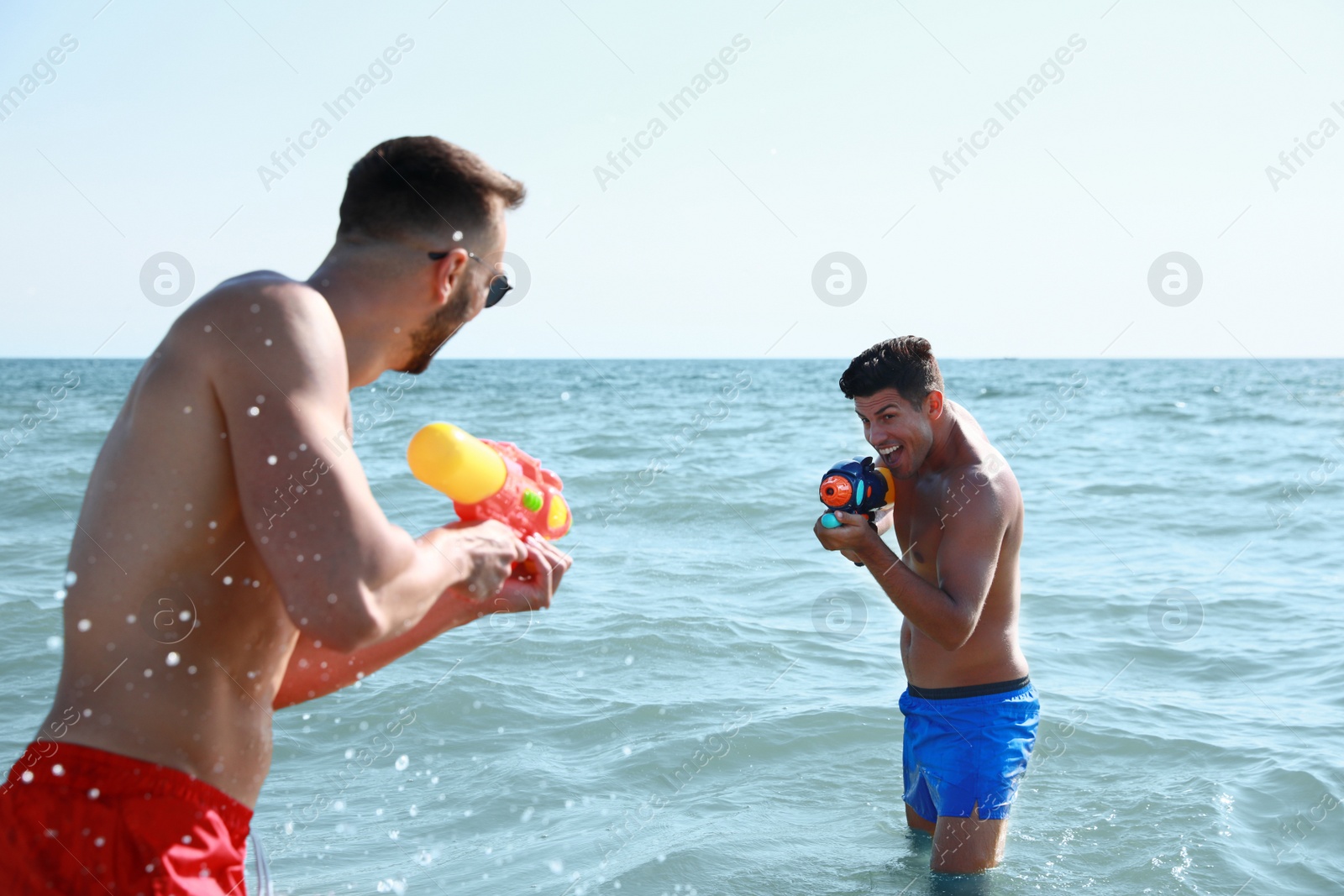 Photo of Friends with water guns having fun in sea