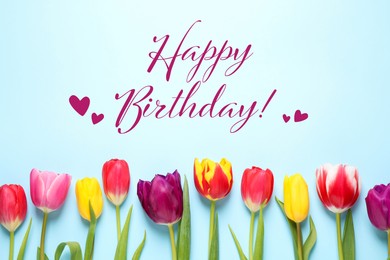 Image of Happy Birthday! Beautiful tulips on light blue background, flat lay.
