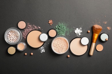 Photo of Flat lay composition with various makeup face powders on dark background