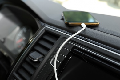 Smartphone with USB charging cable in modern car