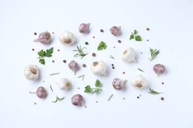 Photo of Fresh raw garlic heads and spices on white table, flat lay