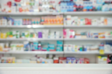 Photo of Blurred view of shelves with pharmaceuticals in modern drugstore
