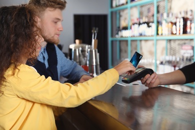 Clients using credit card machine for non cash payment in cafe