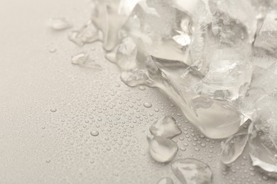 Photo of Pieces of crushed ice on grey background, space for text