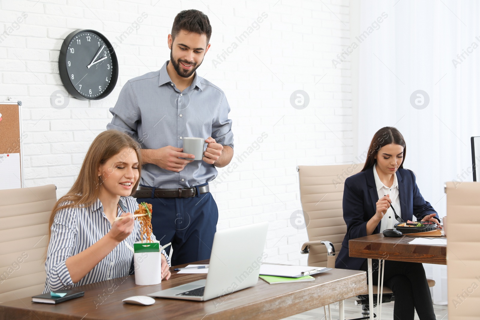 Photo of Office employees having lunch at workplace. Food delivery