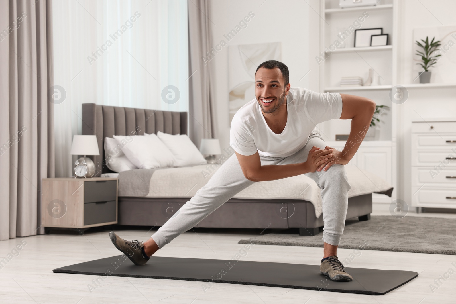 Photo of Man doing morning exercise on fitness mat at home