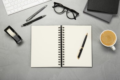 Flat lay composition with notebooks, glasses and coffee on light grey table