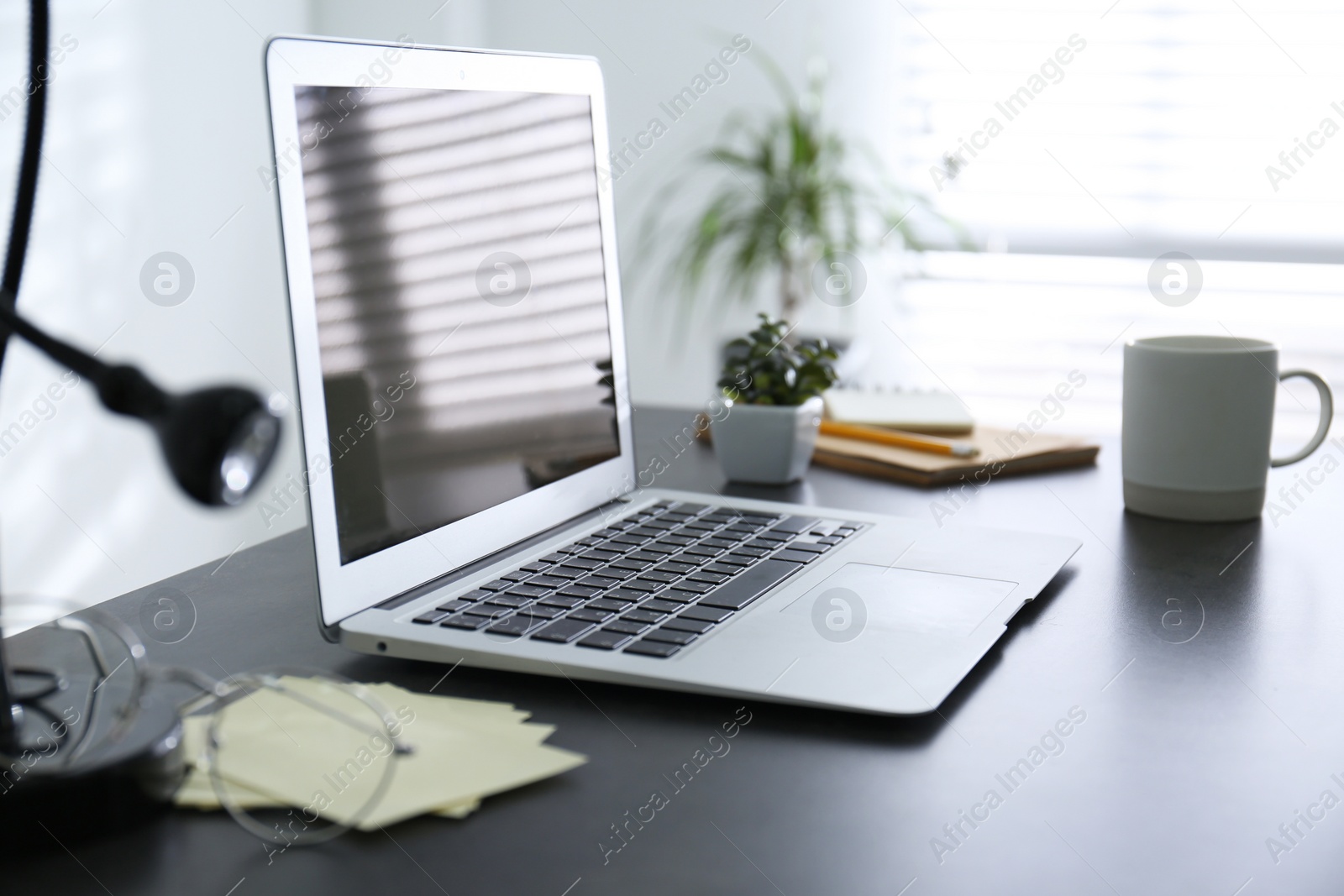 Photo of Modern laptop on office table. Stylish workplace