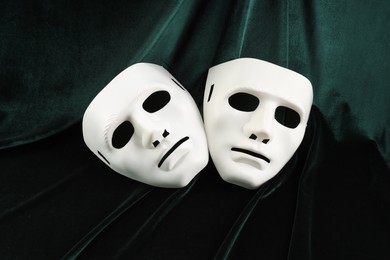 Theater arts. White masks on green fabric