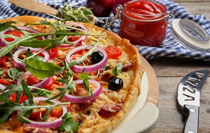Photo of Tasty homemade pizza on wooden table, closeup