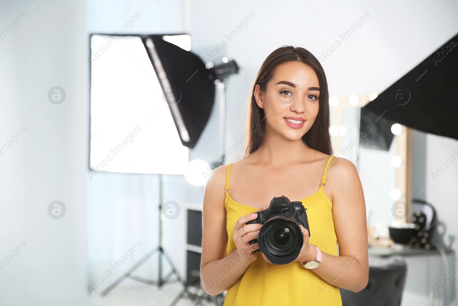 Photo of Professional photographer with camera in photo studio